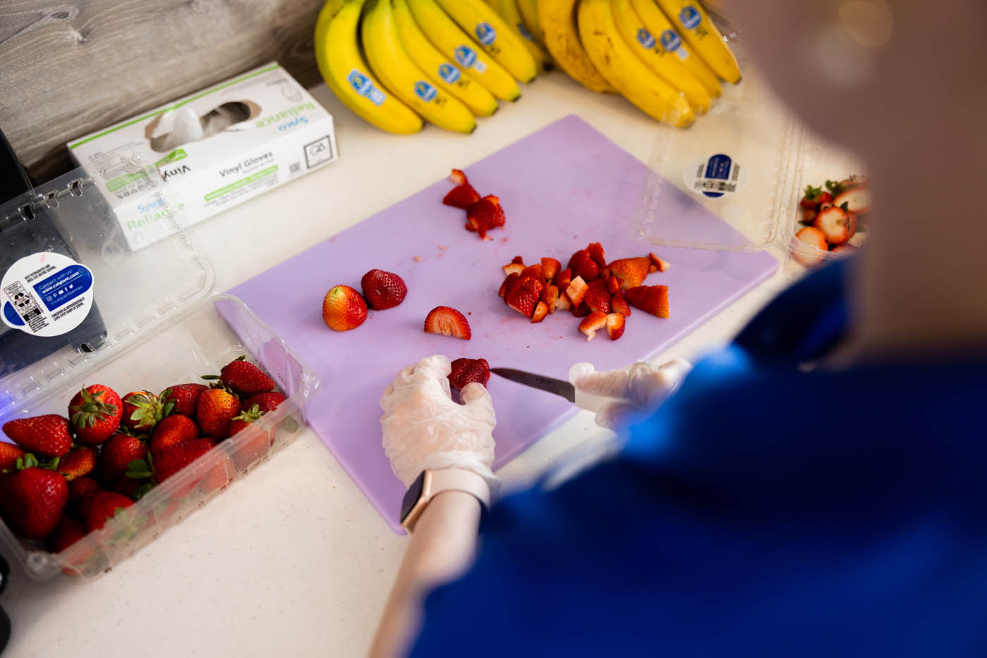A Rush Bowls healthy franchise owner preparing fresh ingredients for a blended fruit bowl.
